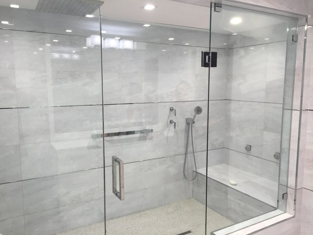 A frameless shower door enclosure
